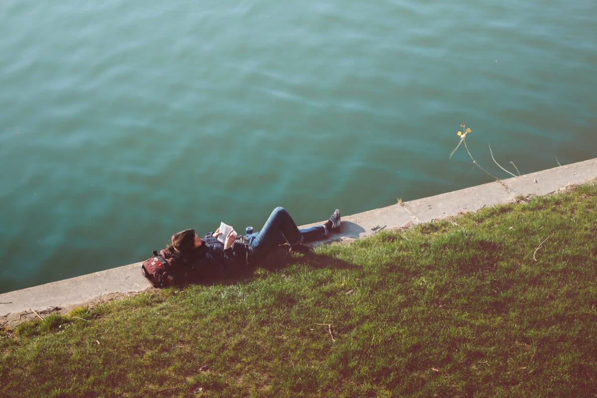 person lying down reading a book alone