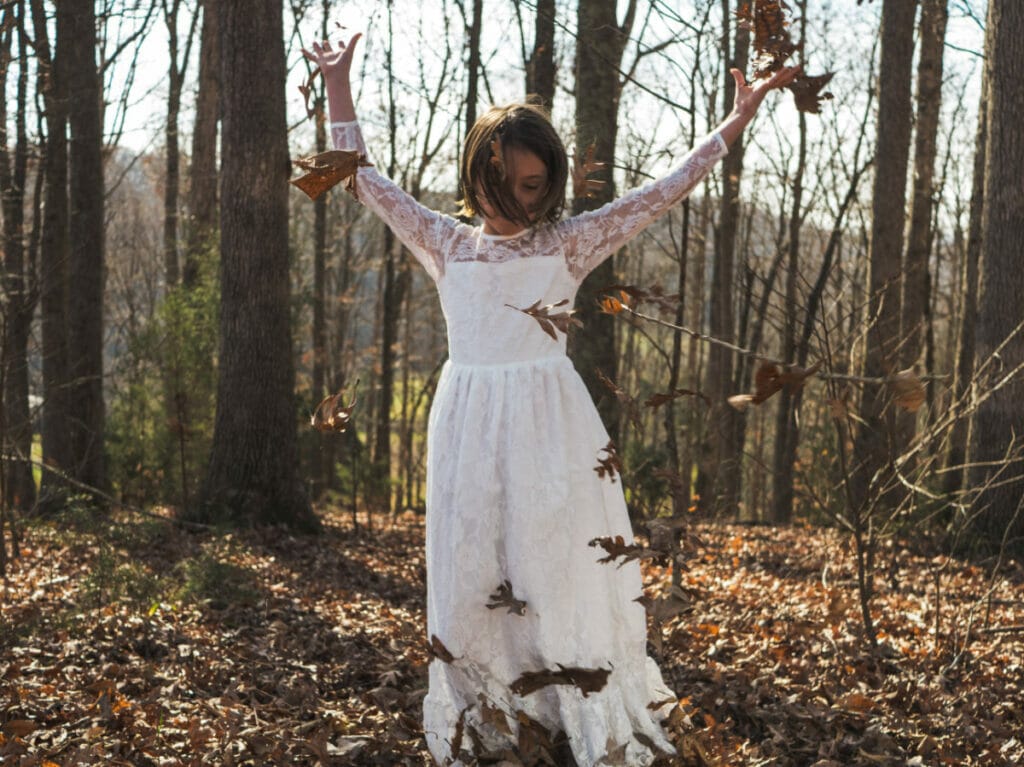 girl playing with leaves alone