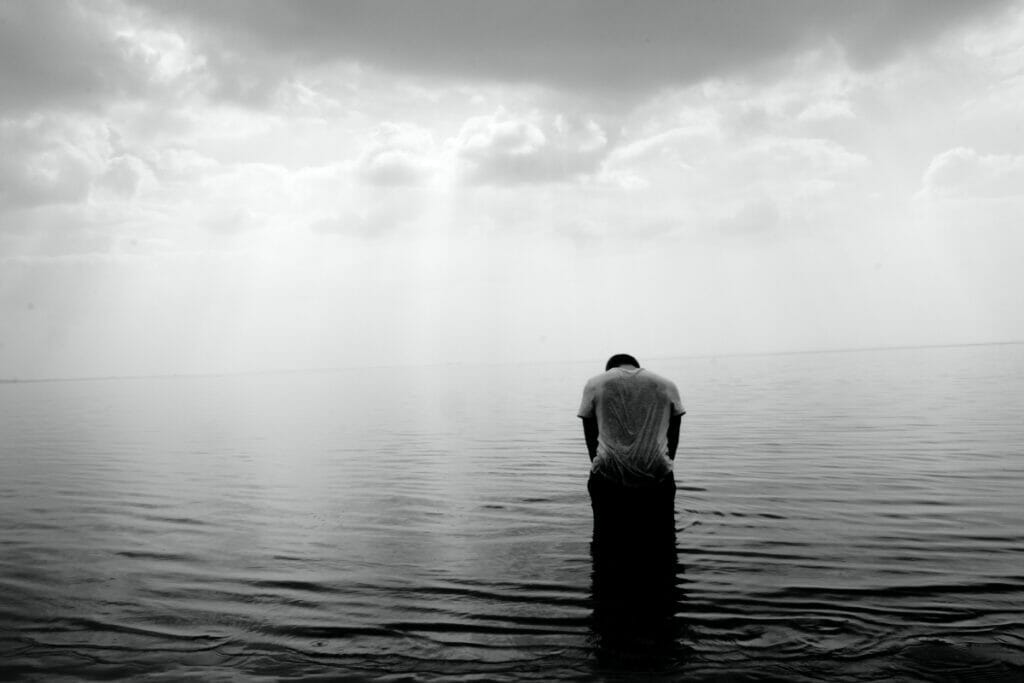 man sitting alone in water