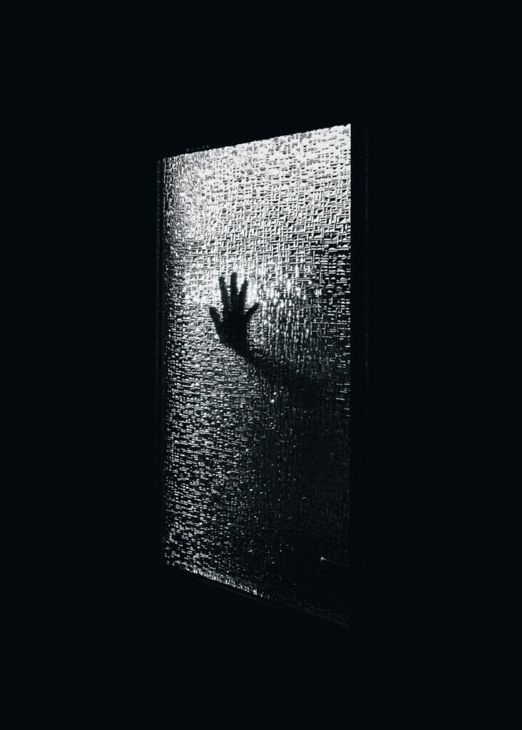 hand touching dark window